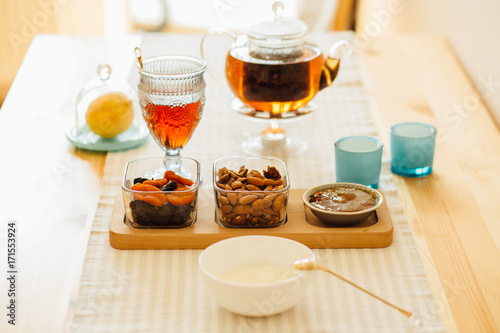 Yogurt, Mixed Nuts and Dried Fruit, Jam, Glass Kettle With Tea. Morning, Breakfast And Healthy Food Concept.