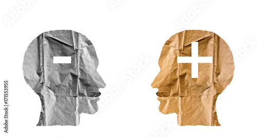 Crumpled paper shaped as a human heads and plus and minus signs.
