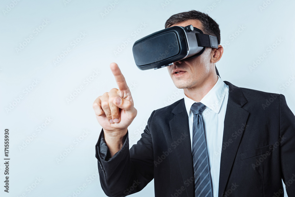 Serious mature man trying on VR glasses