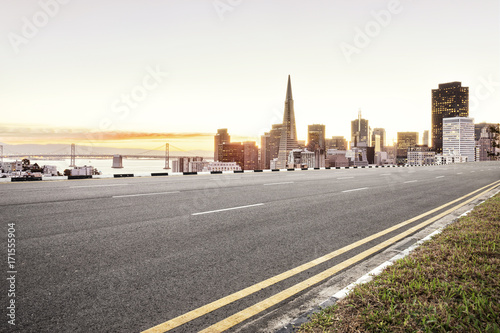 empty asphalt road and cityscape of modern city in blue sky at dawn
