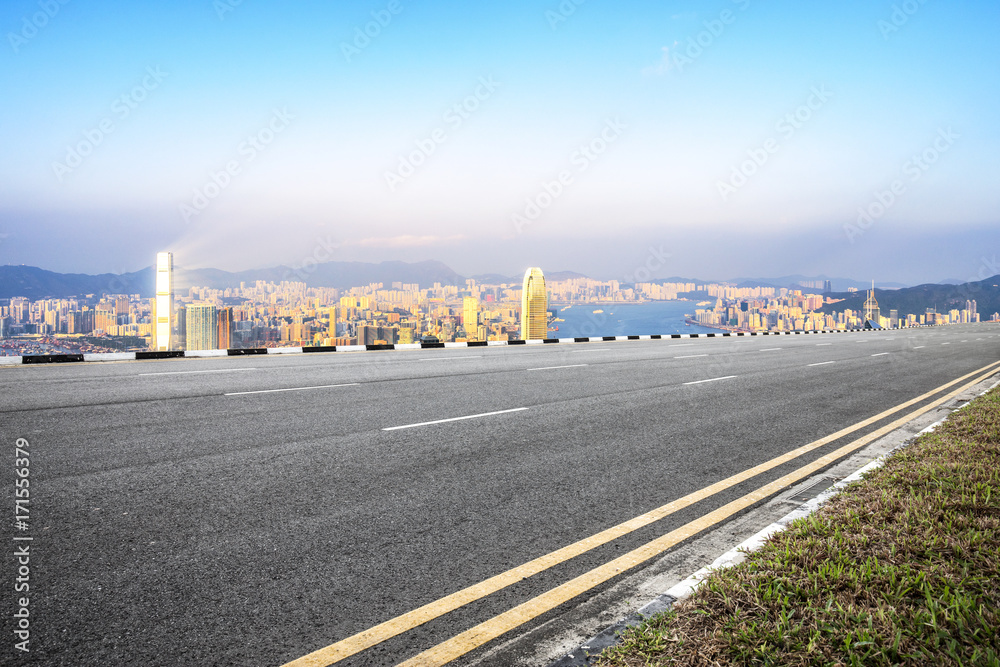 empty asphalt road with cityscape of modern city in blue sky at twilight
