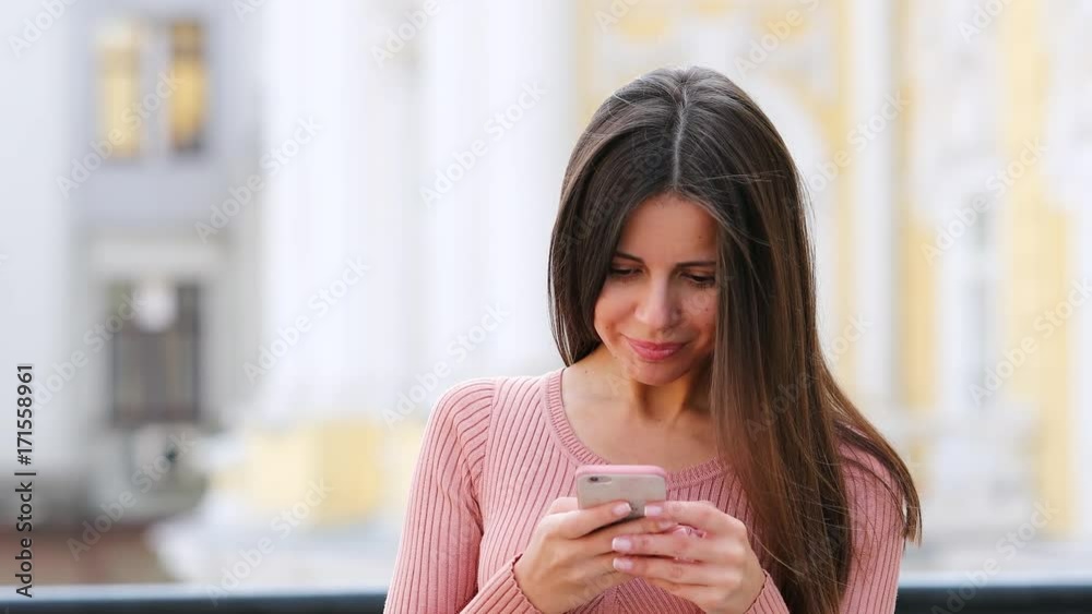SMS. Young brunette woman writing a message in a cell phone SMS. Young brunette woman writing a message in a cell phone
