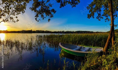 Boat by the lake at sunset © donvictori0
