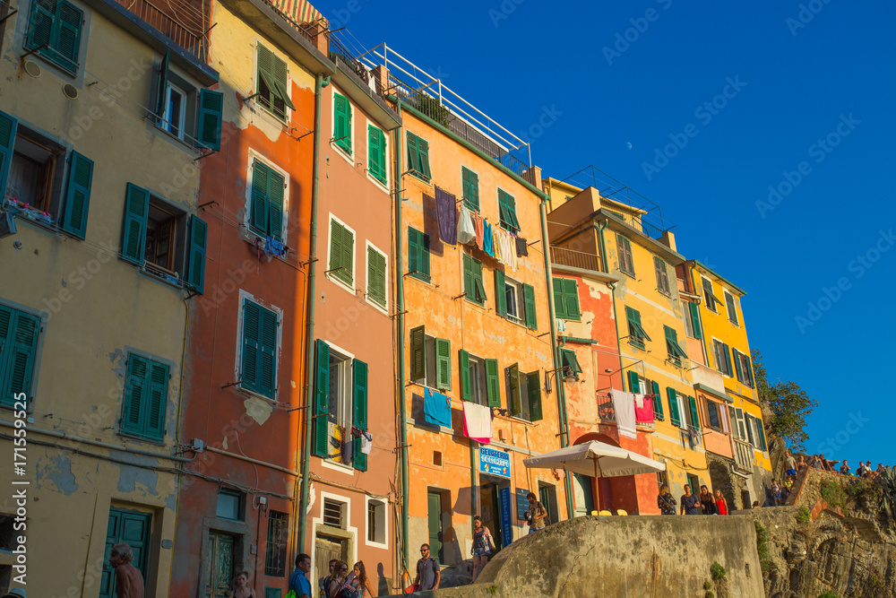 RIOMAGGIORE, ITALY, JULY 31, 2017 - Typical colored houses of Riomaggiore at sunset, 5 Terre, La Spezia province, Ligurian coast, Italy.