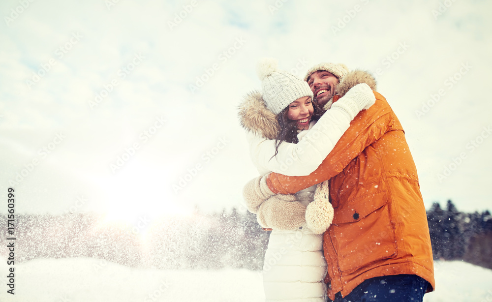 Obraz premium happy couple hugging and laughing in winter