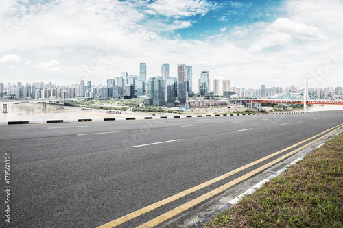 empty asphalt road with modern buildings in blue sky © zhu difeng
