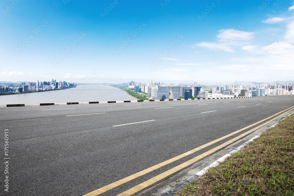 Fototapeta premium pusta droga asfaltowa z nowoczesnymi budynkami w błękitne niebo