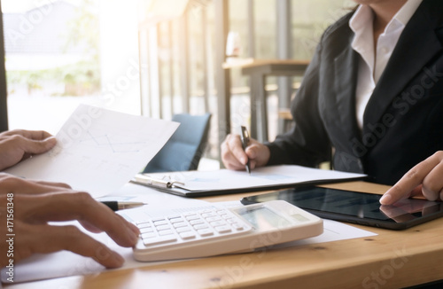 Businessman analyzing investment charts and pressing calculator buttons over documents. Accounting Concept.