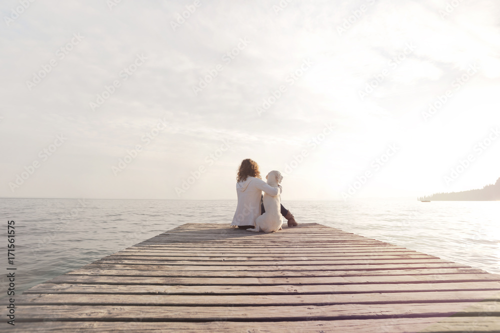 gesture of affection between woman and her dog in front of a spectacular view gesture of affection between woman and her dog in front of a spectacular view