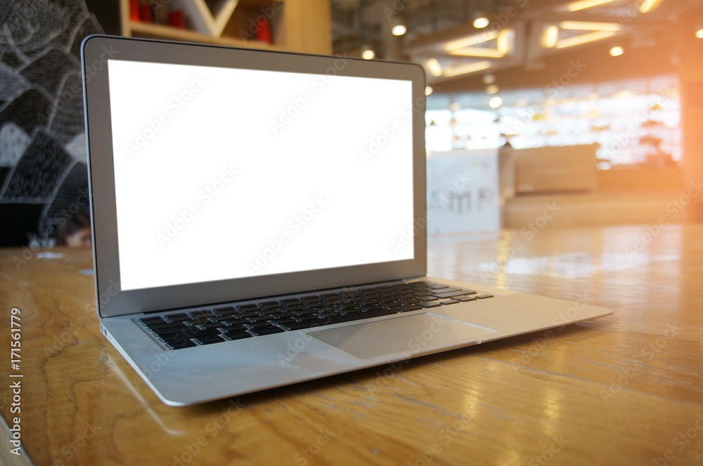 Laptop with blank screen on wooden table in front of coffeeshop cafe - technology concept Laptop with blank screen on wooden table in front of coffeeshop cafe - technology concept