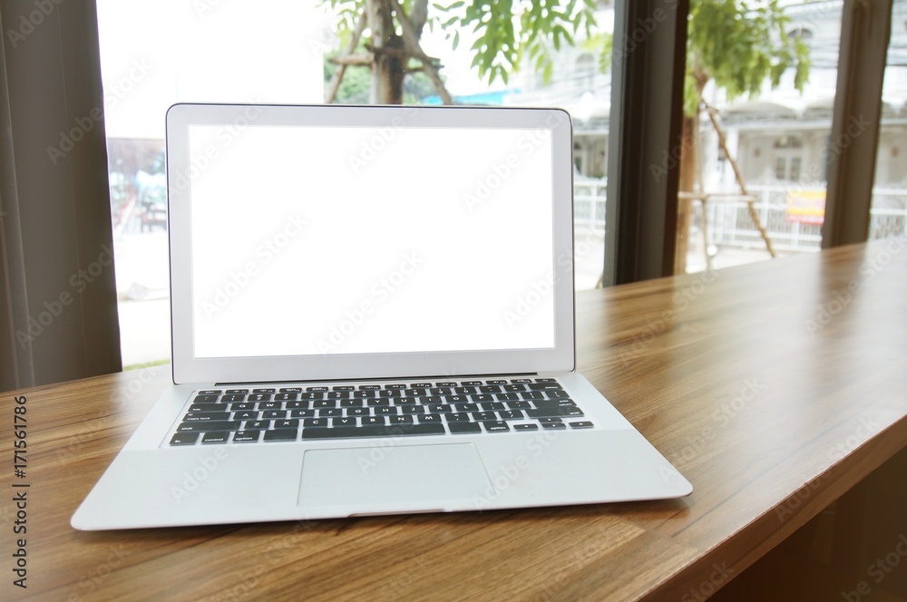 Laptop with blank screen on wooden table in front of coffeeshop cafe - technology concept Laptop with blank screen on wooden table in front of coffeeshop cafe - technology concept