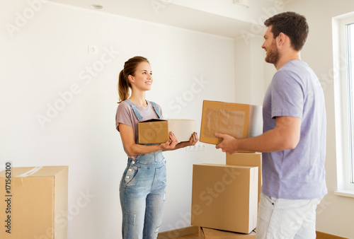 happy couple with boxes moving to new home