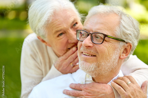 close up of senior couple whispering outdoors