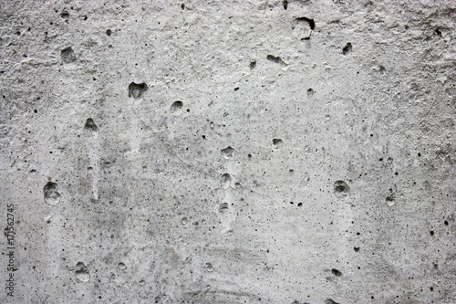 Texture of gray concrete with cracks and pores.