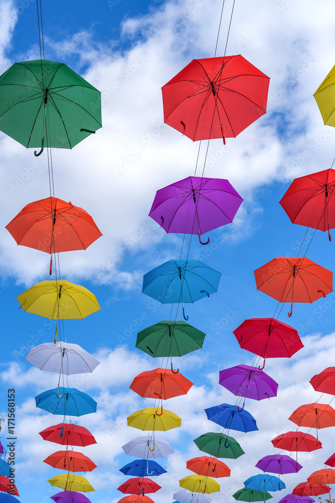 Obraz premium Multicolored umbrellas hanging high above the ground