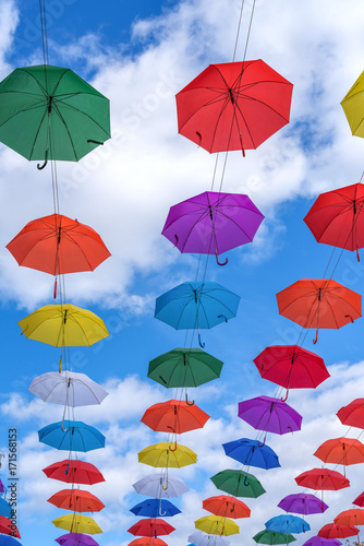 Multicolored umbrellas hanging high above the ground