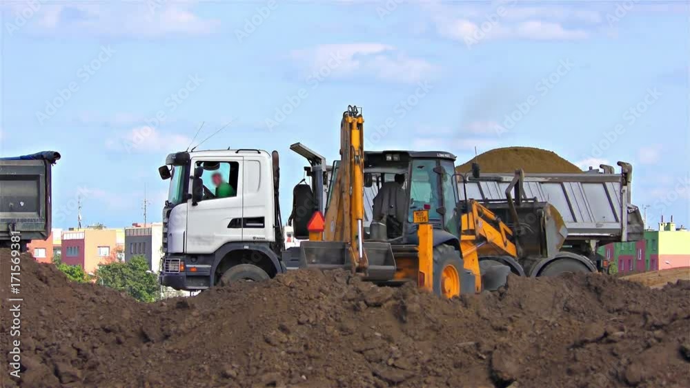 Truck and Excavator with back hoe loading soil, time lapse speed 100x