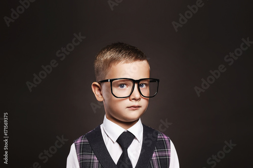 child in glasses near school desk