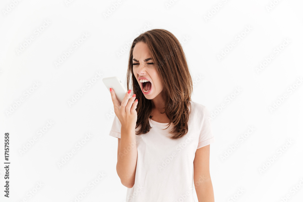 Brunette woman screaming on her smartphone Brunette woman screaming on her smartphone