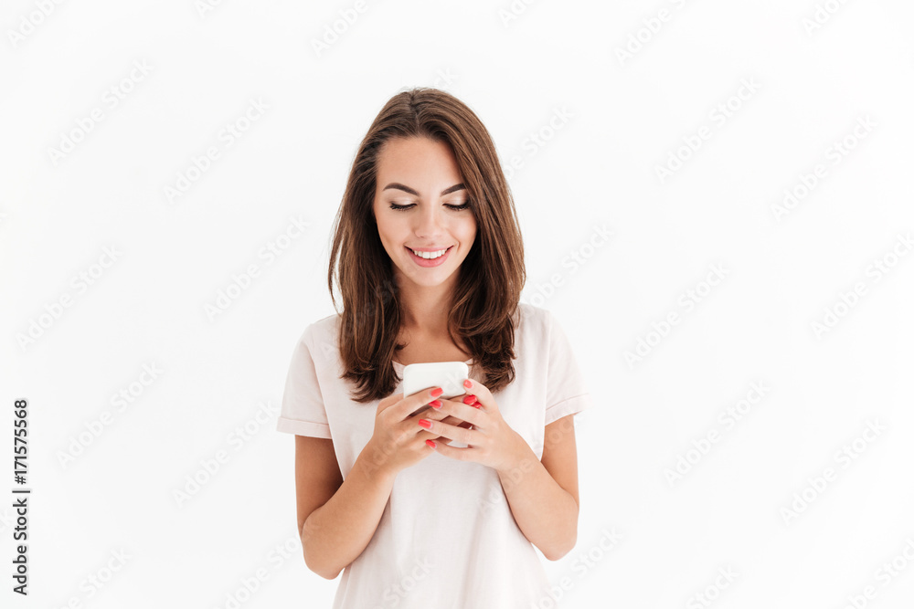 Happy brunette woman writing message on her smartphone