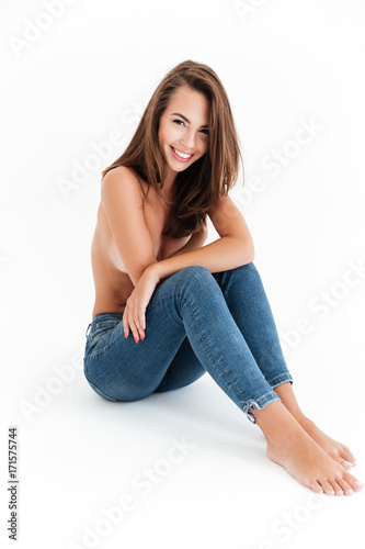 Vertical image of happy half naked woman sitting on floor