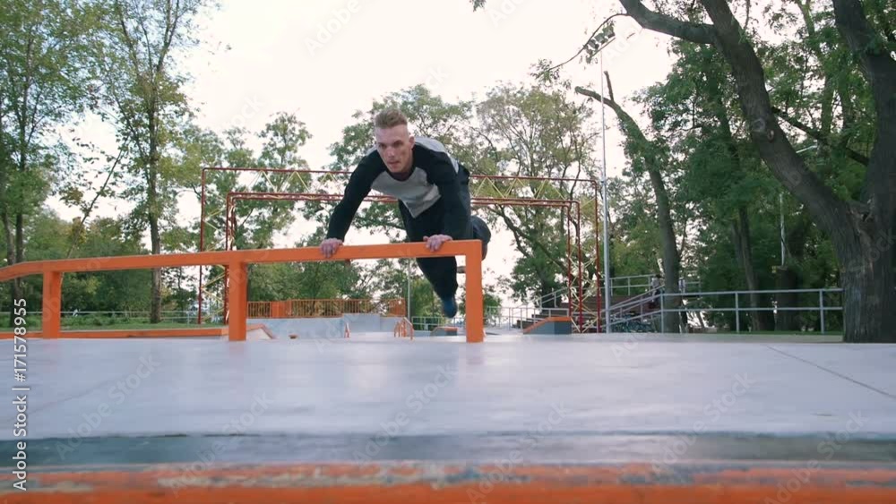 Young man doing parkour tricks in extreme sports park Young man doing parkour tricks in extreme sports park
