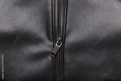 opened zip on black leather surface