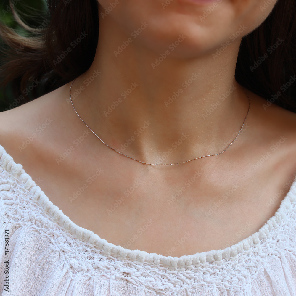 Silver chain at the neck of a woman Silver chain at the neck of a woman