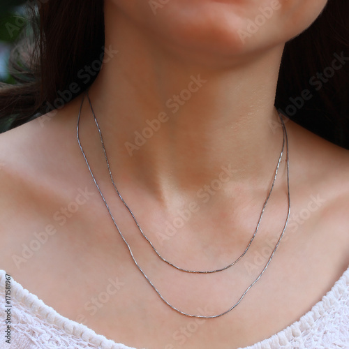 Silver chain at the neck of a woman