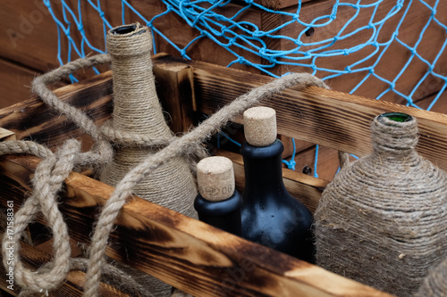 Decorative bottles in a wooden box in a marine style