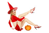 Beautiful blond smiling girl in Halloween witch costume sitting on white background