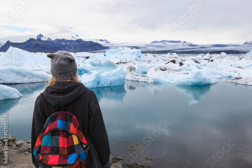 Back view of traveler young girl  with backpack. Glacier lagoon Jokulsarlon, Iceland
