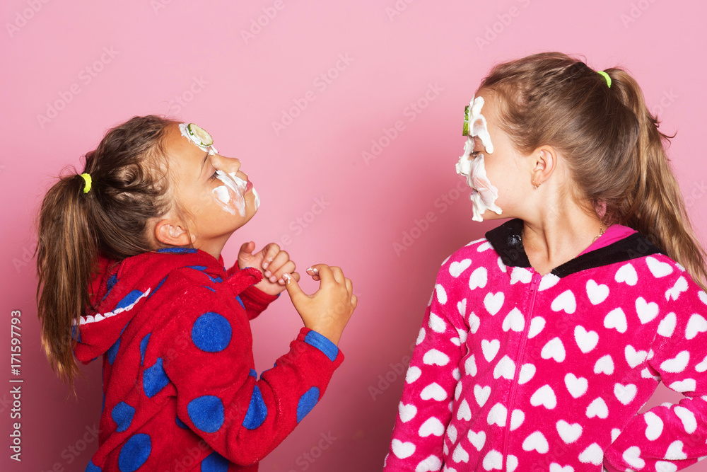 Kids pose on pink background. Girls in polka dotted pajamas Kids pose on pink background. Girls in polka dotted pajamas