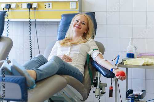 young caucasian woman with toy heart in the hand donates blood for saving lives and medical research