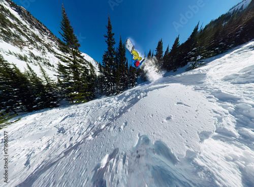 Snowboarder freerider jumping from snow ramp. Wide-angle aerial panorama