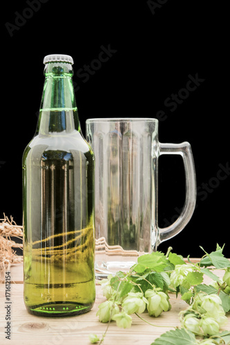 bottle of beer with hop and wheat and a glass