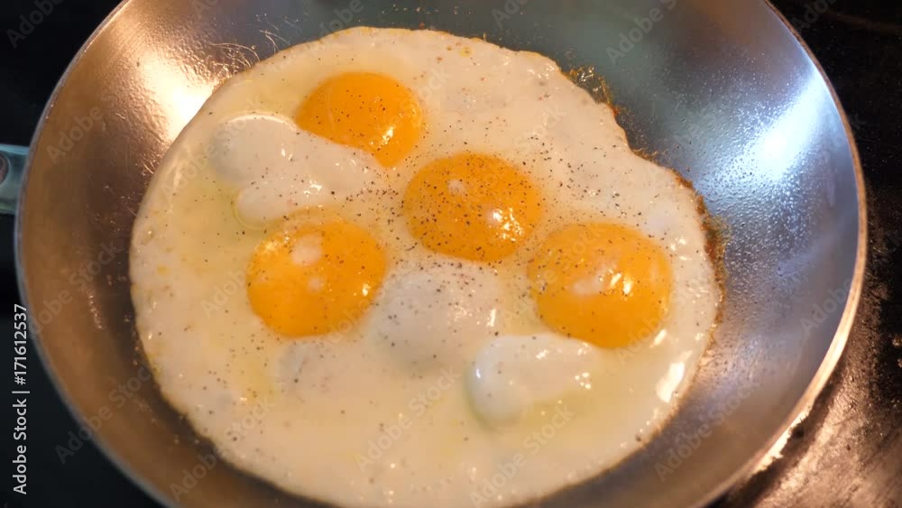 Applying pepper to some eggs with cooking Applying pepper to some eggs with cooking