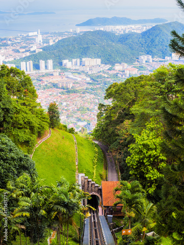 The scenery from Penang Hill station, Penang, Malaysia, showing the track and tunnel in the foreground and the city, mountain and sea in the background.