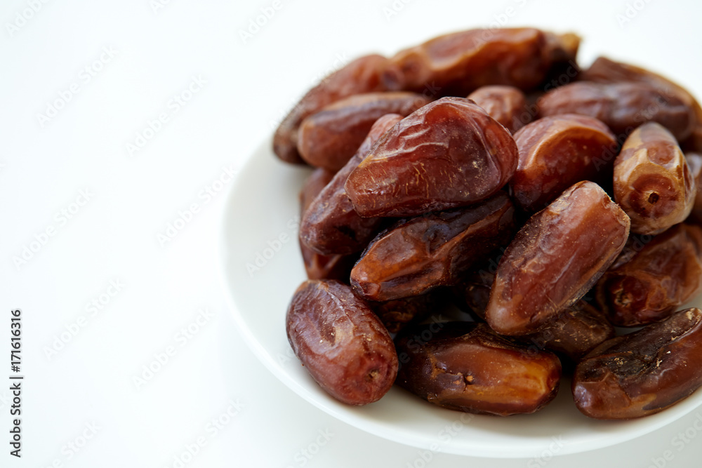 Bowl of dried dates isolated on white backgroun
