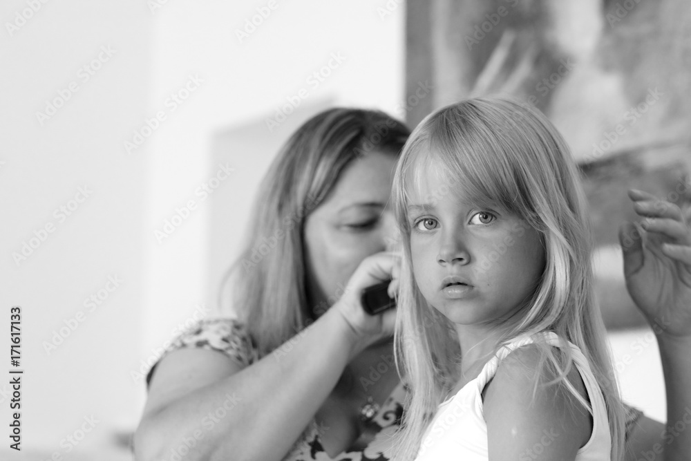 Portrait of a girl with a woman combing her hair Portrait of a girl with a woman combing her hair