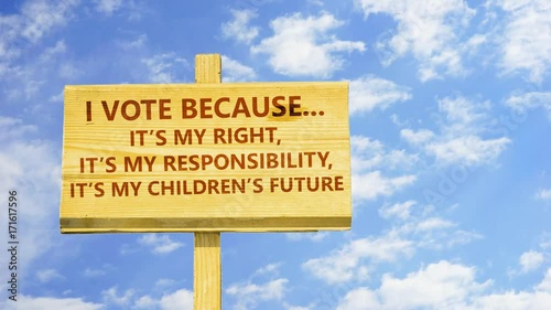 I vote because it's my right, responsibility, anf my chilfren's future. Words on a wooden sign against time lapse clouds in the blue sky.  photo