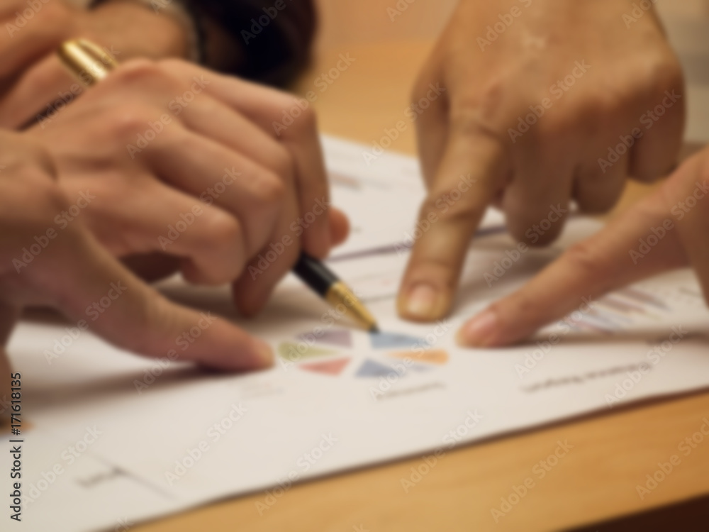 The blurry light design of business worker hands is point to investment chart The blurry light design of business worker hands is point to investment chart