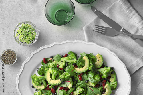 Superfood salad with avocado, beans and broccoli on white ceramic plate, top view