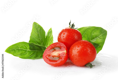 Cherry tomatoes and green fresh organic basil isolated on white