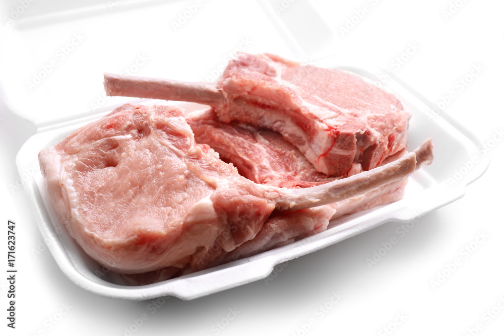 Raw ribs in container on white background