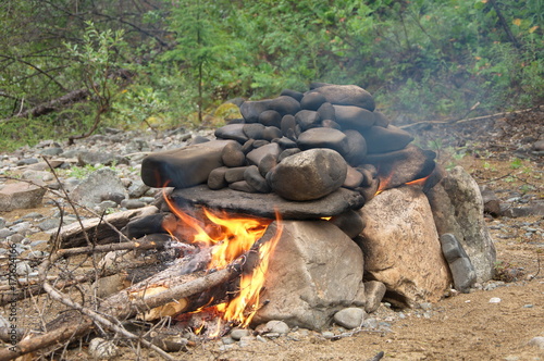 Stone fireplace for hiking Russian bath in the wild taiga.