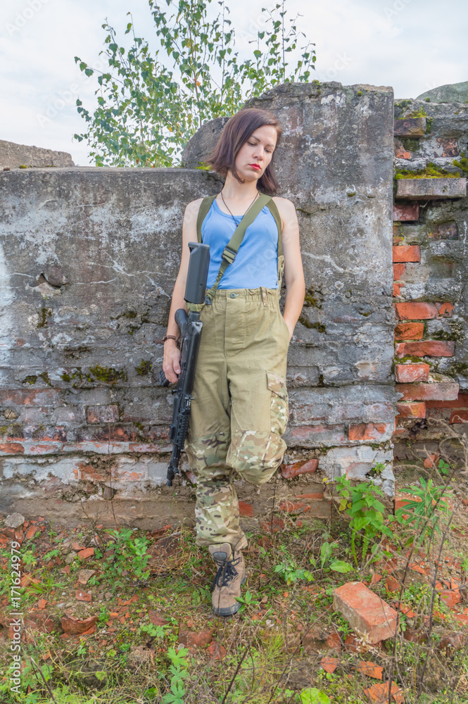 Fototapeta premium concrete wall posing girl with a gun.
