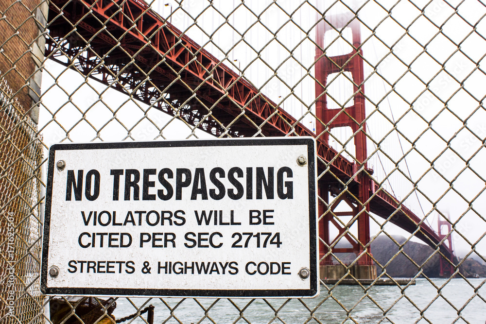 A 'No Trespassing' sign in Fort Point, with the Golden Gate Bridge in the background A 'No Trespassing' sign in Fort Point, with the Golden Gate Bridge in the background