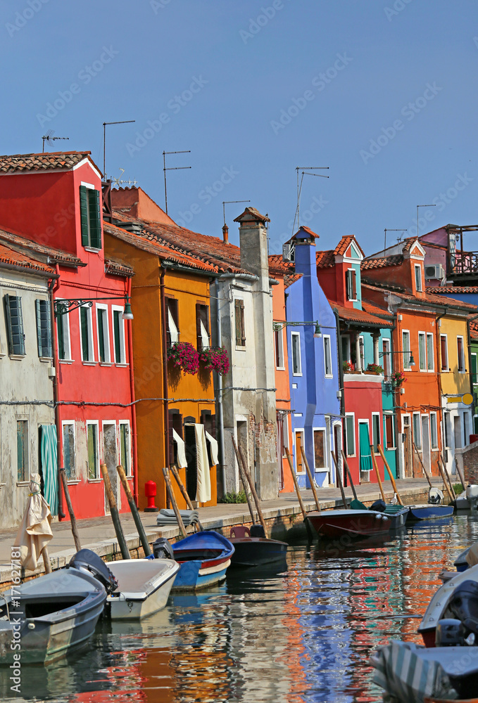 colored houses in the island of Burano in Venice and the reflect