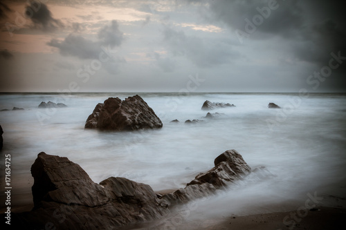 Schilderij op canvas Sunset over Rocks at Widemouth Bay, Cornwall